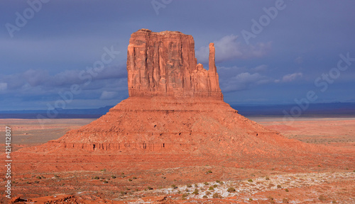 west mitten butte in winter against a stormy sky in the navajo tribal park of monument valley, utah