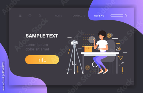 woman technology blogger opening box with headphones recording unboxing video with camera on tripod blogging live streaming concept copy space horizontal full length