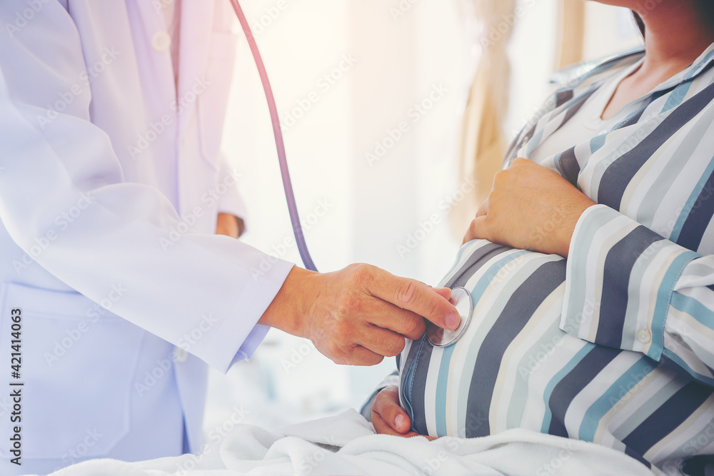 Crop image of Doctor using stethoscope for examining pregnant woman at hospital. selected focus Crop image of Doctor using stethoscope for examining pregnant woman at hospital. selected focus