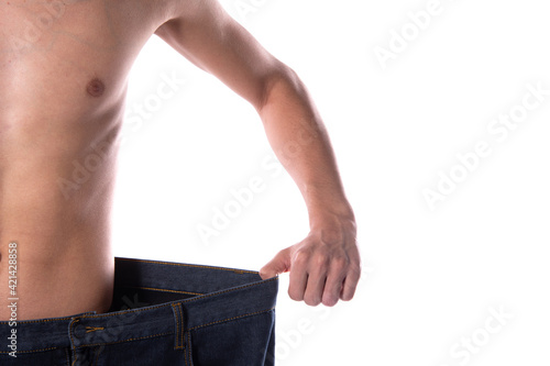 Funny young guy in big pants. Diet and weight loss. The result of fitness and training. White background. Isolate.