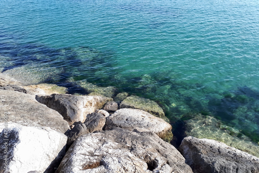 Vista sul mare sulla bellissima acqua blu verde dalla costa rocciosa di Fano, Italia
