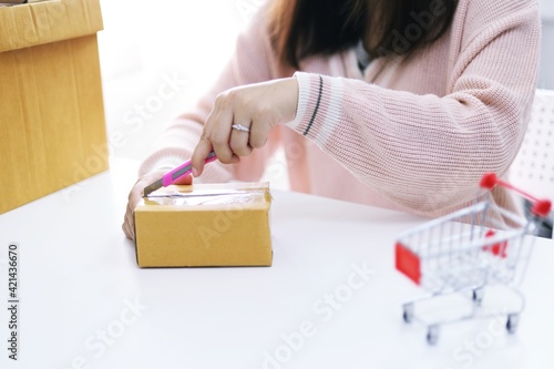 Woman unpacking unboxing after buying ordering online shopping at home