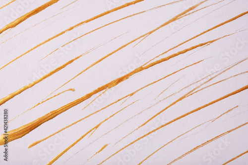 Thin golden lines and splashes drawn on white background. Abstract art backdrop with yellow brush decorative stroke.