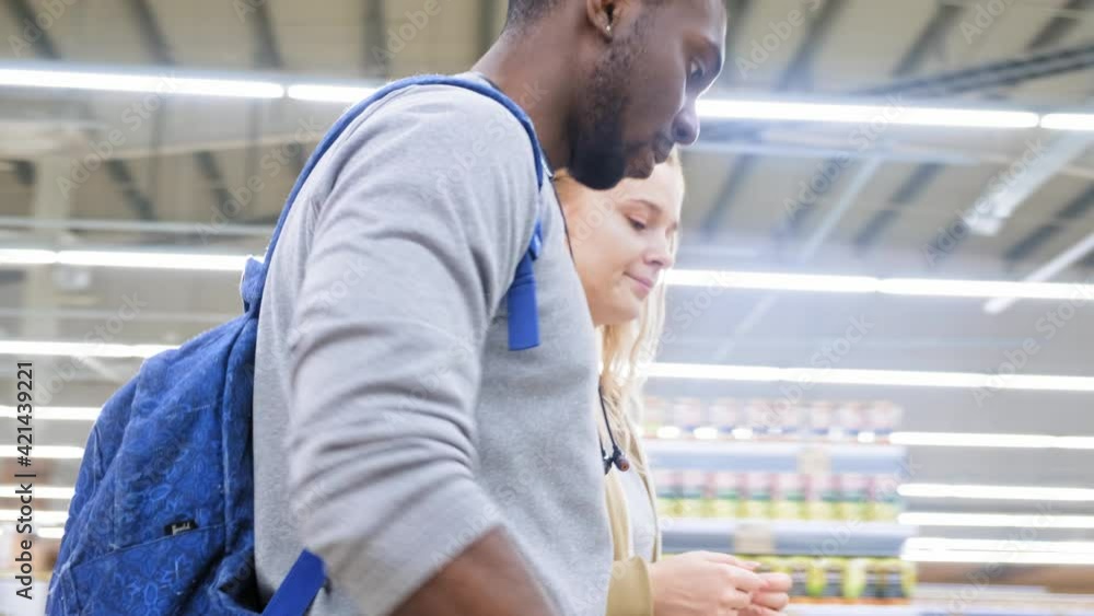 Multiethnik couple in the supermarket with a trolley Multiethnik couple in the supermarket with a trolley
