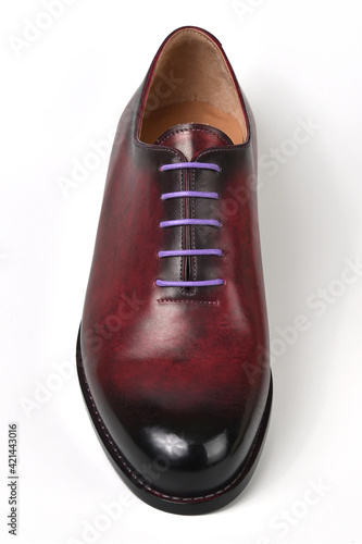 Maroon male shoe with lilac shoelaces on a white background.