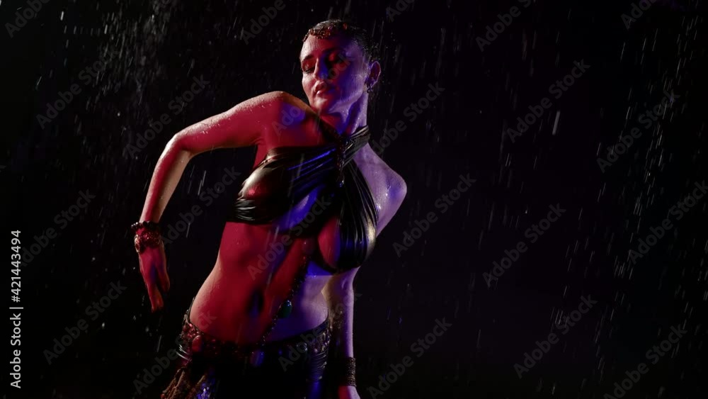 sexy woman with big breasts is dancing exotic oriental dance under rain at night sexy woman with big breasts is dancing exotic oriental dance under rain at night