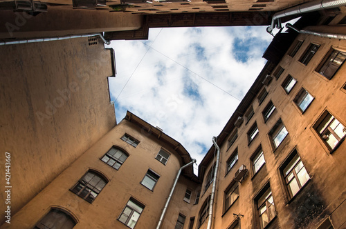 Low angle view of typical yard-well over blue sky and clouds in the old district of the city, Saint Petersburg, Russia