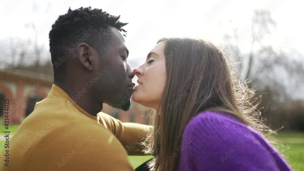 Young interracial couple kissing outside. Black man with white ...