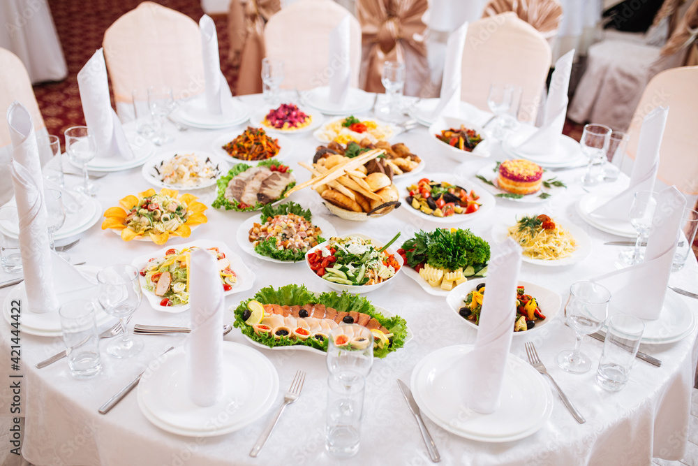 Served restaurant banquet white round table with oriental cuisine appetizers