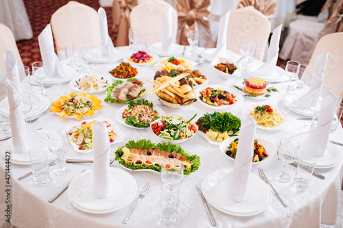 Served restaurant banquet white round table with oriental cuisine appetizers