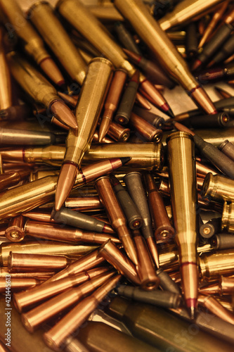 Pile of bullets with copper tips under a warm light. Close up of a lot of bullets. Gun violence in America. Ammunition rifle or pistol. toned