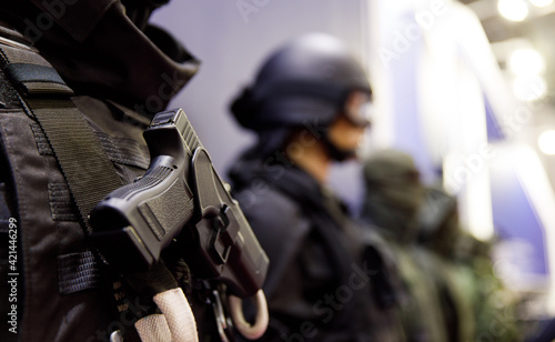 Close up soldier keeping modern gun while wearing bulletproof vest. Uniform concept. photo