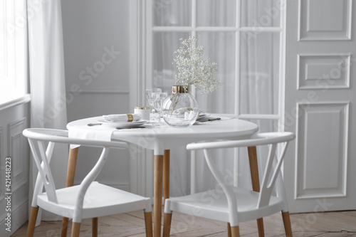 White loft interior in a Scandinavian style with a table. Set wooden table in a bright interior, photo studio. © pavelvozmischev
