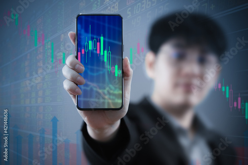 Investor and trader concept - investor with Smart phone and tradeview graph and marketting reports on Smart phone screens in his modern. photo