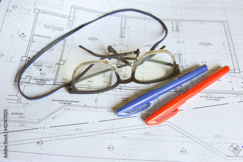 Glasses with red and blue pen to mark up architectural drawing