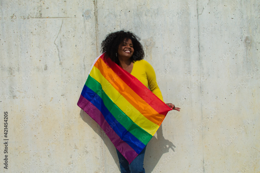 Very Happy African American Lesbian Woman With The Gay Pride Flag On Her Body On A Grey