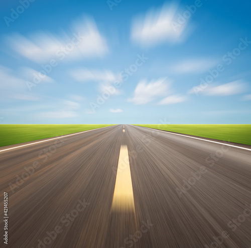 Motion blur of highway in perspective and nature landscape. Consist of long straight line on asphalt road or way and empty horizon sky background at outdoor. Concept for drive car, race, speed, fast.