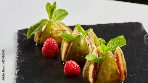 The figs with cheese garnished with mint leaves and raspberries and strawberries. Mediterranean cuisine. Shallow dof.