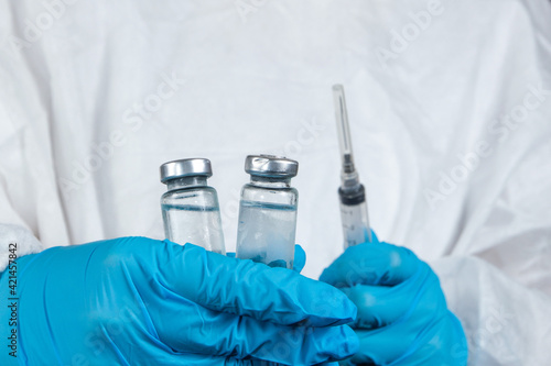 covid-19 sars-cov-2 vaccination: a health worker with a vaccine and a syringe in his hands