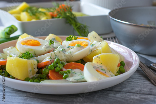 boiled eggs with vegetables, potatoes and sauce on a plate