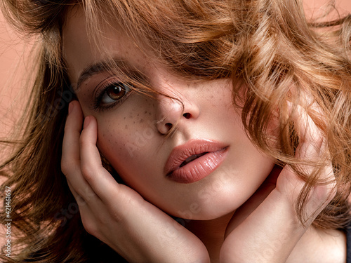 Beautiful face of an white woman. Beautiful brown haired with stylish short hairstyle. Woman with a  curly hair. Sensual young woman with freckles on face. Attractive girl with a brown makeup. photo
