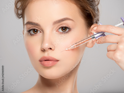 Woman getting cosmetic injection of botox in cheek, closeup. Woman in beauty salon. plastic surgery clinic. Cosmetology procedures concept. Beauty treatment therapy.