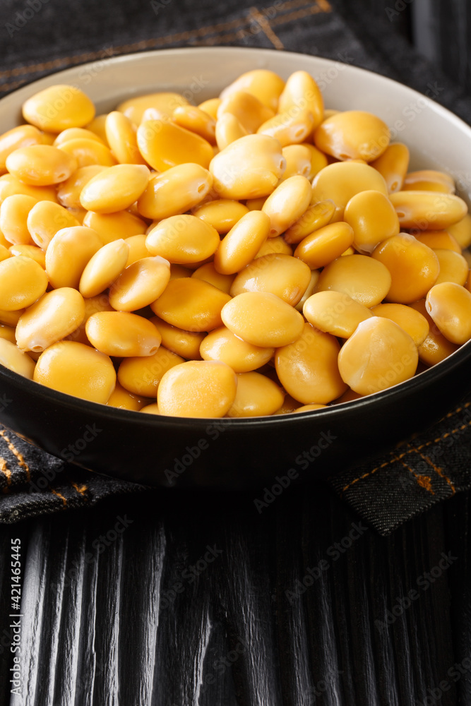 Delicious Mediterranean lupine beans close-up in a bowl on the table. Vertical Delicious Mediterranean lupine beans close-up in a bowl on the table. Vertical