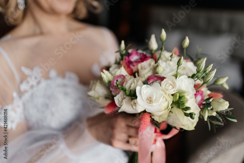 Bride holding wedding bouquet from white and pink flowers
