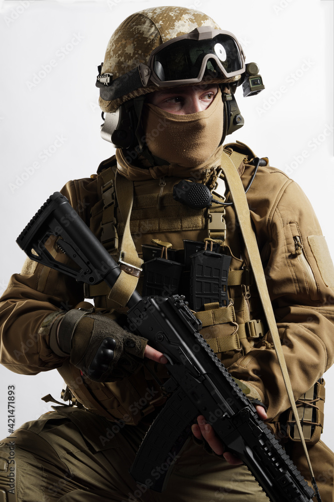 Male soldier in tactical equipment and uniform (coyote brown color) . Shot in studio on a white background Male soldier in tactical equipment and uniform (coyote brown color) . Shot in studio on a white background