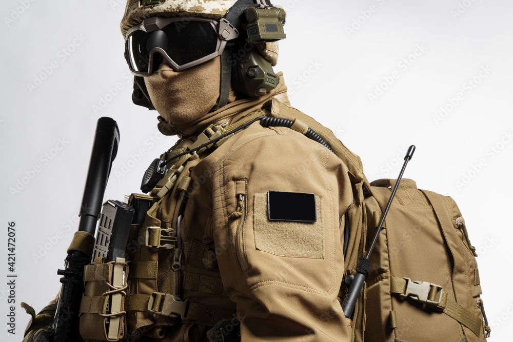 Male soldier in tactical equipment and uniform (coyote brown color) . Shot in studio on a white background Male soldier in tactical equipment and uniform (coyote brown color) . Shot in studio on a white background