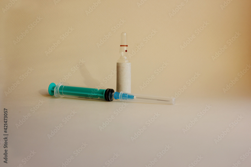 A syringe with a needle, amulets with medicine on a blue background. Vaccination. Coronavirus. The concept of medicine and immunity. Vaccination against viral infections. Flatly. Copy space A syringe with a needle, amulets with medicine on a blue background. Vaccination. Coronavirus. The concept of medicine and immunity. Vaccination against viral infections. Flatly. Copy space