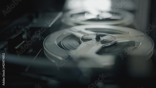 Vintage tape recorder roller. Reel film tape is rotating at a oldschool professional player. Concept of spying and recording a phone conversations