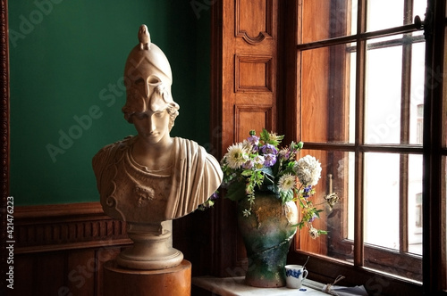 Classic Mars sculpture with bouquet of flowers in old vase