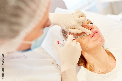 Woman applying hyaluronic acid to her lips