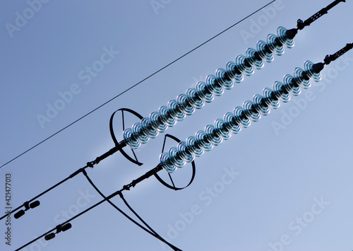 power line of cables and insulators close up. electrical insulators support cables placed on bracket installed on power pole. Clear blue sky without cloud background. Concept of industrial