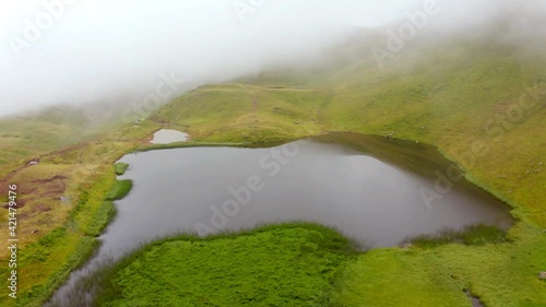 4k drone forward video (Ultra High Definition). Aerial summer scene of Dohyaska lake. Foggy morning view from flying drone of Carpathian mountains, Ukraine, Europe. photo