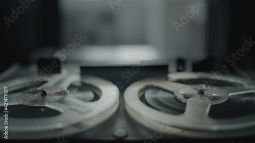 Vintage tape recorder roller. Reel film tape is rotating at a oldschool professional player. Concept of spying and recording a phone conversations
