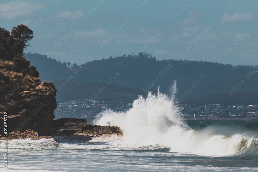 big waves crashing against rocky shoreline in Tasmania, Australia