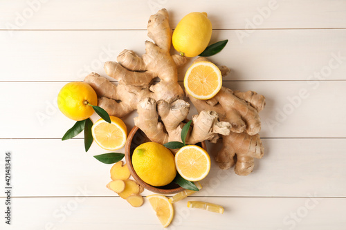 Fresh lemons and ginger on white wooden table, flat lay