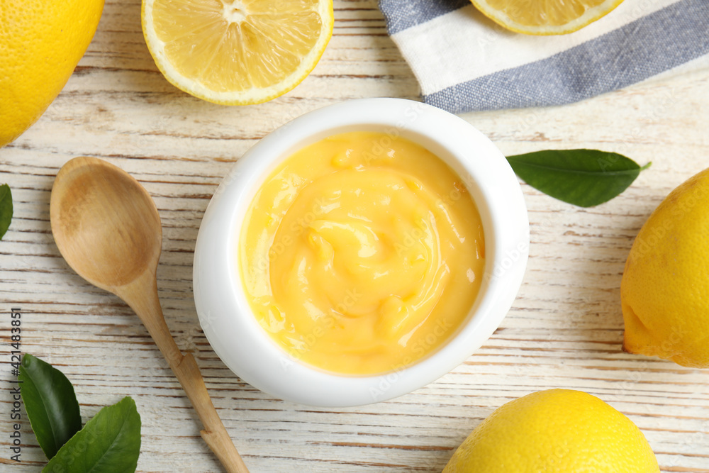 Delicious lemon curd in bowl on white wooden table, flat lay Delicious lemon curd in bowl on white wooden table, flat lay