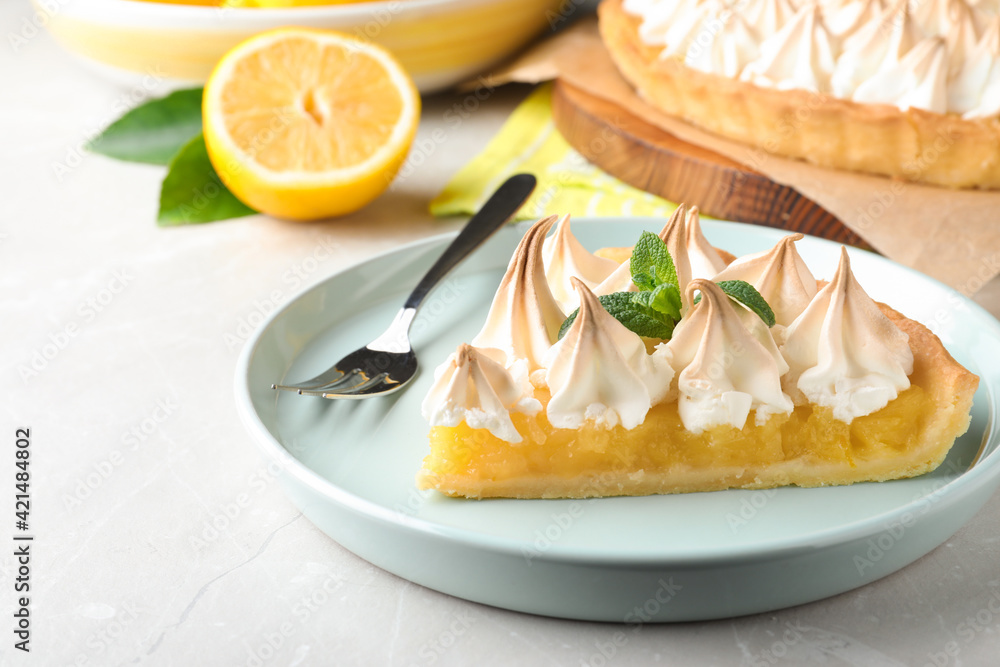 Piece of delicious lemon meringue pie with mint served on light table, closeup Piece of delicious lemon meringue pie with mint served on light table, closeup
