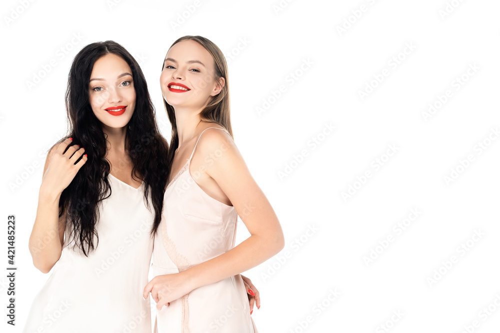 happy women in dresses smiling while standing isolated on white happy women in dresses smiling while standing isolated on white
