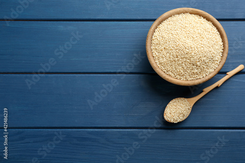 Sesame seeds on blue wooden table, flat lay. Space for text photo