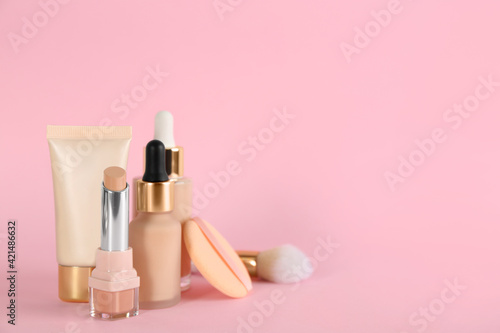 Foundation makeup products on pink background, space for text. Decorative cosmetics