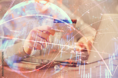 Double exposure of man hands holding a credit card and Forex graph drawing. Stock trading and digital fintech in Internet E-commerce concept.