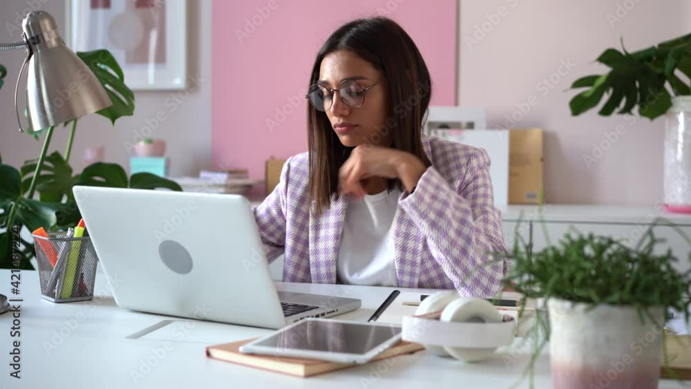 Indian mixed-race businesswoman working on laptop computer in office. Female manager typing on laptop keyboard indoors Indian mixed-race businesswoman working on laptop computer in office. Female manager typing on laptop keyboard indoors
