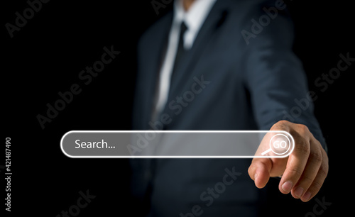 Businessman hand pressing blank search bar on a virtual online computer or screen to Searching for information.