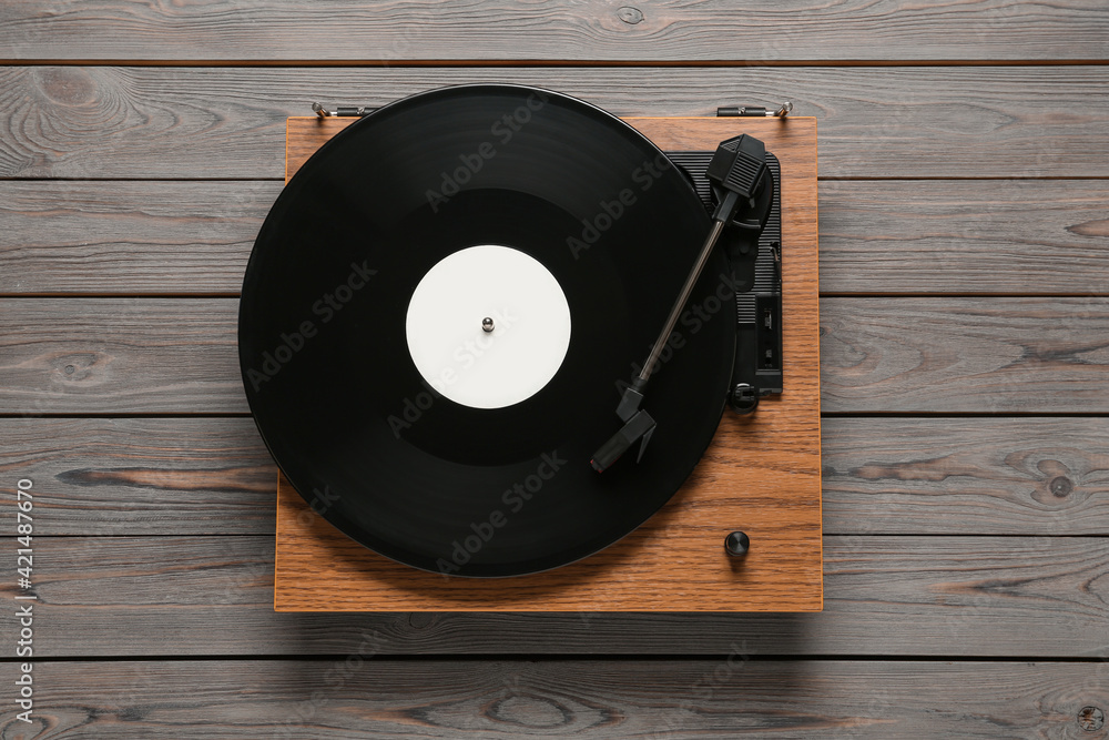 Obraz premium Turntable with vinyl record on wooden background, top view