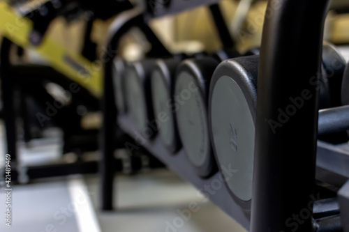 Gym background Fitness equipment dumbbells weight for a workout. Background image of dumbbells in row on equipment stand in modern gym. Dumbbells on the racks at the gym,exercise and relaxing concept.