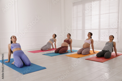Trainer working with group of pregnant women in gym. Preparation for child birth